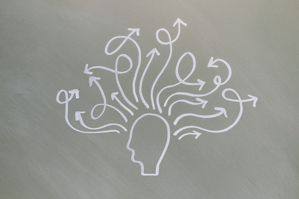 Conceptual chalk drawing illustrating mental health challenges with arrows representing thoughts.